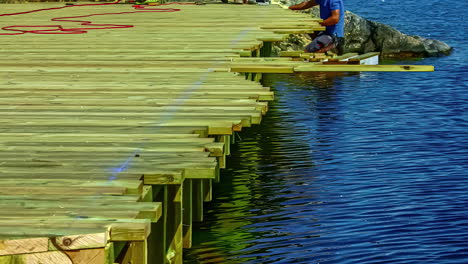 Hyper-lapse-of-builders-building-a-wooden-deck-on-water-using-tools