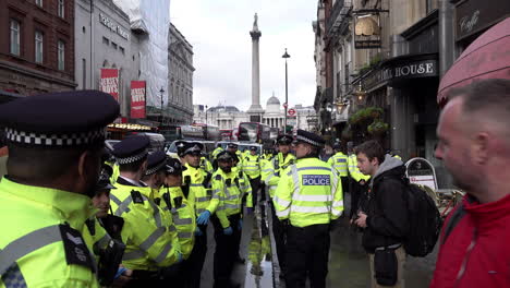 Metropolitan-police-officers-form-a-cordon-along-the-roadside-in-front-of-Nelson’s-Column,-to-prevent-any-protesters-from-re-entering-the-road-during-a-Just-Stop-Oil-protest