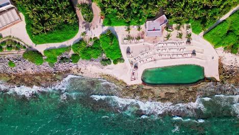 TRS-Yucatan-Resort-in-Tulum-Mexico-straight-down-aerial-view-of-the-salt-water-pool-and-the-Caribbean-Sea-with-large-waves-crashing-on-the-beach-near-the-infinity-pool