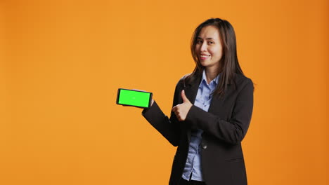 Businesswoman-holding-phone-with-greenscreen-template