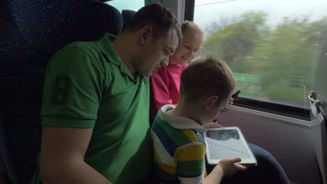 Family-traveling-by-train-and-using-digital-tablets