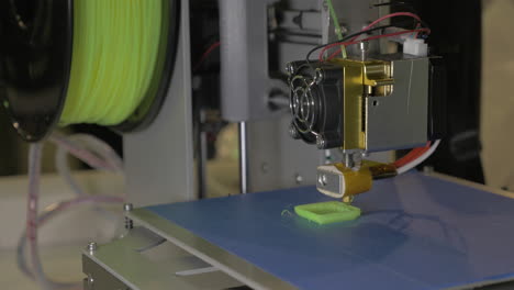 3d-printer-in-process-It-makes-pieces-for-equipment-with-green-plastic