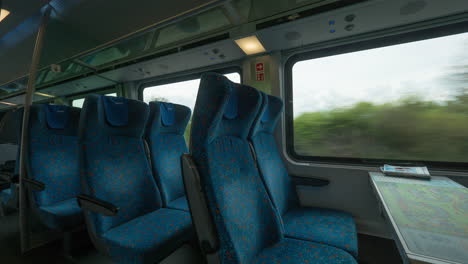 Zeitrafferaufnahme-Im-Inneren-Eines-Modernen-Leeren-Eisenbahnwaggons-Mit-Tischsitzplätzen-Und-Fenstern-In-Wien,-Österreich