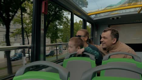 Family-of-tourists-traveling-by-double-decker-bus-in-Vienna