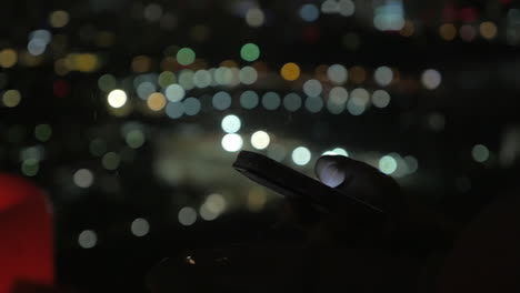 Surfen-Auf-Dem-Smartphone-Bei-Nächtlichen-Lichtern-Der-Stadt-Im-Hintergrund