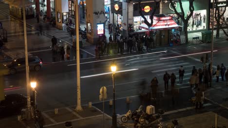 Timelapse-of-night-city-with-busy-intersection-with-passing-cars-and-pedestrians