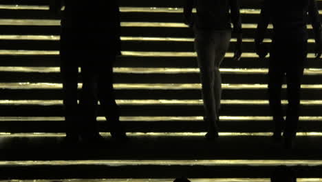 Silhouettes-of-people-going-up-and-down-against-lighting-gold-stairway-Bangkok-Thailand