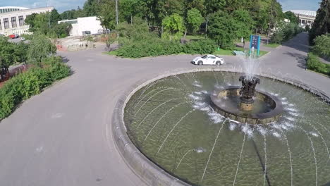 Car-driving-around-the-fountain-aerial-view