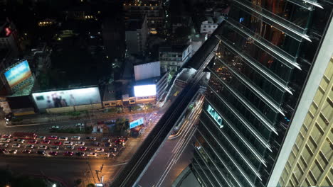 Time-lapse-night-view-of-big-multi-level-traffic-road-intersection-near-skyscraper