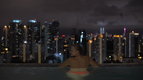 Paar-Schaut-Nachts-Auf-Kuala-Lumpur-Vom-Pool-Auf-Dem-Dach-In-Malaysia