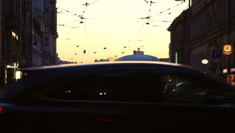 Bei-Sonnenuntergang-An-Der-Kreuzung-überqueren-Menschen-Die-Straße,-Vorbei-An-Autos