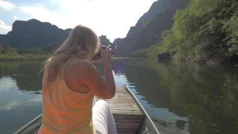 Woman-tourist-taking-shots-of-Trang-An-nature-Vietnam
