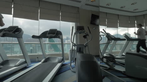 Woman-exercising-on-running-machine-in-front-of-panoramic-window