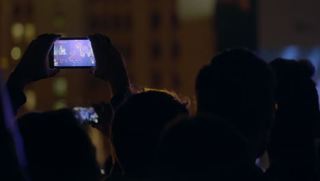 Zuschauer-Nimmt-Bei-Einem-Musikkonzert-Im-Freien-Per-Smartphone-Ein-Video-Mit-Zoom-Auf-Der-Bühne-Und-Auf-Der-Großen-Leinwand-Auf