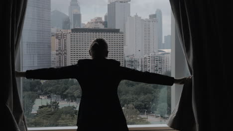 Zeitlupenclip-Einer-Frau,-Die-Vorhänge-öffnet,-Mit-Blick-Auf-Hongkong,-China