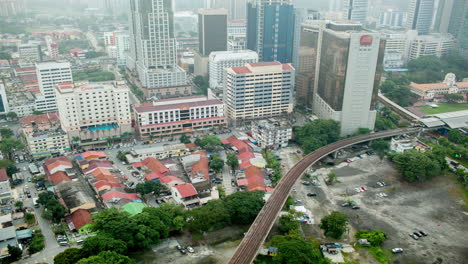 Bird-eye-time-lapse-view-of-railways-across-road-against-city-landscape-Kuala-Lumpur-Malaysia