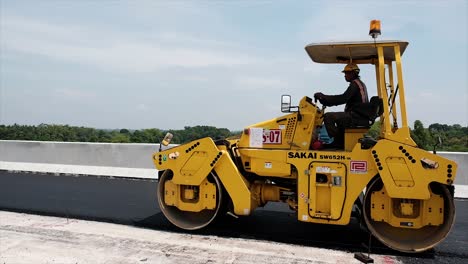 Compressing,-compacting,-leveling-and-smoothing-the-asphalt-road-surface-using-a-tandem-roller