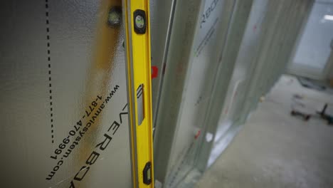 DeWalt-Level-leaning-against-soundproof-wall,-construction-site
