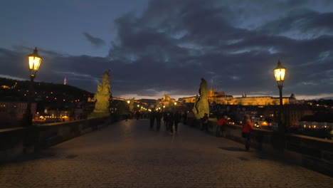 Abendstadtbild-Mit-Gehenden-Menschen-Auf-Der-Malerischen-Karlsbrücke-In-Prag,-Tschechische-Republik