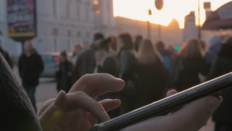 Woman-using-cellphone-in-the-city-at-sunset