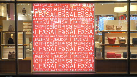 Store-front-with-sale-banner-illuminated-at-night
