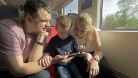 View-of-happy-family-in-the-railway-trip-using-smartphone