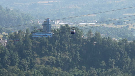 A-cable-car-crossing-a-deep-gorge-covered-with-trees-in-Kushma,-Nepal