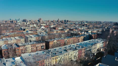 Unglaubliche-Drohnenaufnahme-Aus-Der-Luft-Von-Reihen-Von-Wohnungen-Und-Mietshäusern-In-Brooklyn,-New-York,-Mit-Der-Skyline-Von-Manhattan,-New-York-City-Im-Hintergrund
