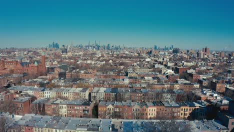Incredible-aerial-drone-shot-of-rows-of-Brooklyn-New-York-apartments-and-tenement-buildings-with-the-Manhattan-New-York-City-skyline-in-the-background
