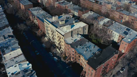 Incredible-aerial-drone-shot-of-Brooklyn-New-York-apartments-and-tenement-buildings,-as-pedestrians-and-cars-pass-by