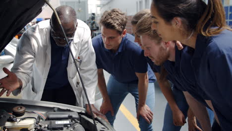 Tutor-Explaining-How-Engine-Works-To-Group-Of-Apprentices