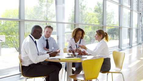 Business-Team-Having-Meeting-Around-Table-In-Modern-Office