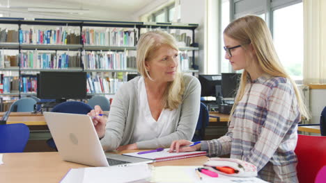 Teacher-And-Female-Student-Work-On-Computer-In-College-Library