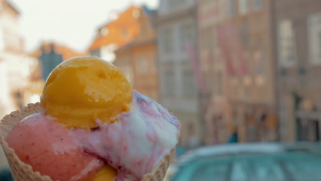 Slow-motion-view-of-unfocused-cityscape-on-the-background-and-then-seen-ice-cream-balls-in-the-waffle-cup-Prague-Czech-Republic