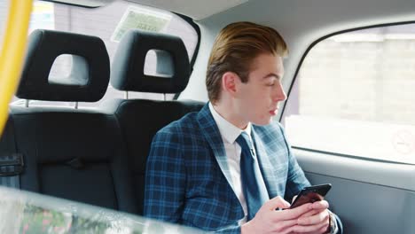 Stylish-Man-Wearing-Suit-Using-Mobile-Phone-In-Taxi-Cab