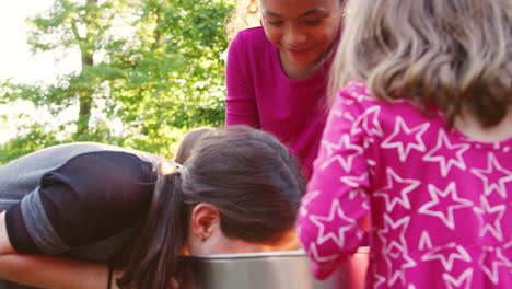 Three-young-girls-apple-bobbing-at-a-backyard-party