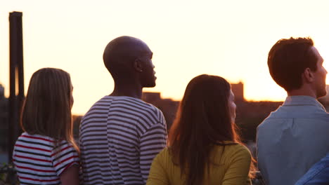 Friends-admiring-the-view-from-a-rooftop-at-sunset,-close-up