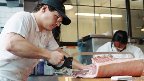 Two-butchers-preparing-meat-to-sell-at-a-butcher's-shop