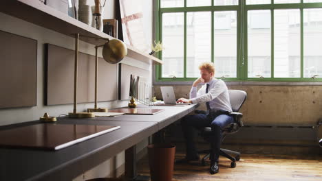 Young-businessman-using-laptop-alone-in-a-small-office