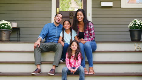 Portrait-Of-Family-Sitting-On-Steps-In-Front-Of-House