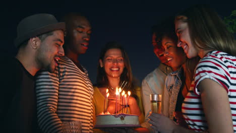 Amigos-Celebrando-Con-Un-Pastel-De-Cumpleaños-Al-Aire-Libre-Por-La-Noche.