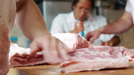Joven-Carnicero-Preparando-Carne-En-La-Carnicería,-Sección-Intermedia
