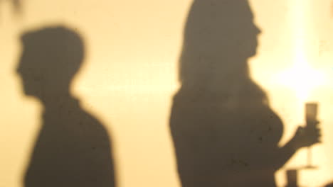 Shadows-of-adult-friends-socialising-on-a-rooftop,-close-up