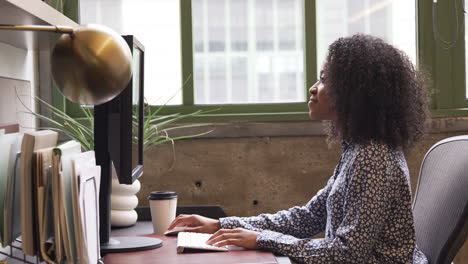 Junge-Schwarze-Frau-Benutzt-Computer-In-Einem-Büro,-Seitenansicht