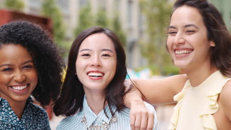 Female-colleagues-smiling-to-camera-outside-their-workplace