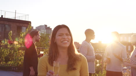 Young-Hispanic-woman-at-a-rooftop-party-smiling-to-camera