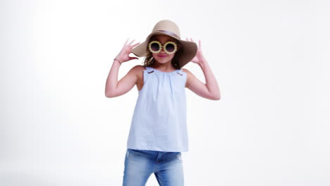 Girl-Wearing-Hat-And-Sunglasses-Poses-Against-White-Background