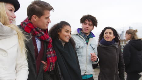 Group-Of-Young-Friends-Walking-Over-Millennium-Bridge-In-London