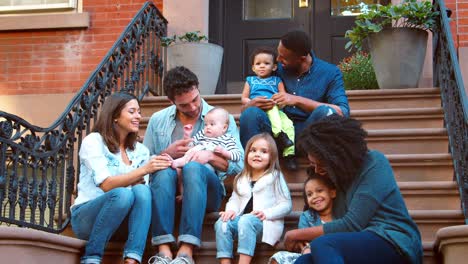 Two-families-with-kids-sitting-on-front-stoop-in-Brooklyn
