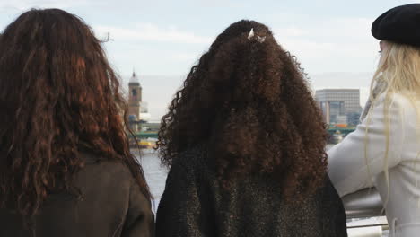 Rear-View-Of-Female-Friends-Visiting-London-In-Winter